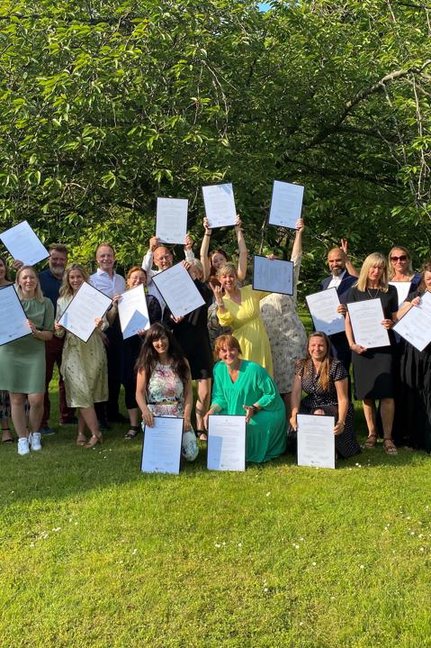 A group photo of the professional members of SES Family standing under a tree
